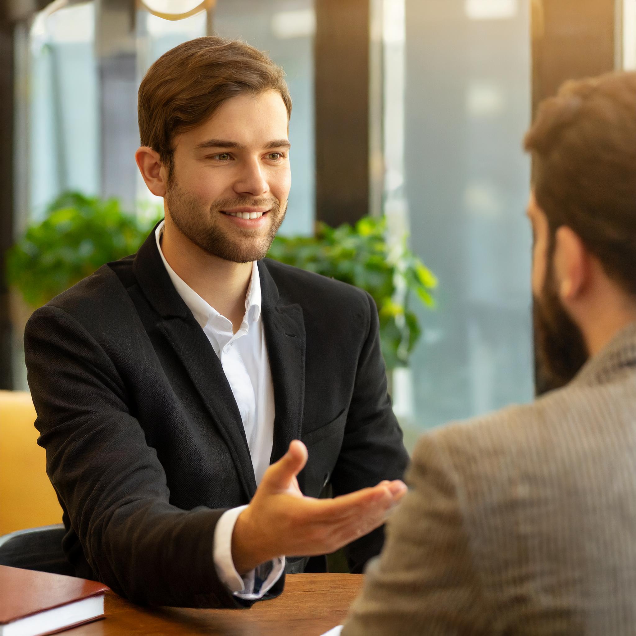 Steuerberater im Gespräch mit Kunden in einem elegant eingerichteten Büro